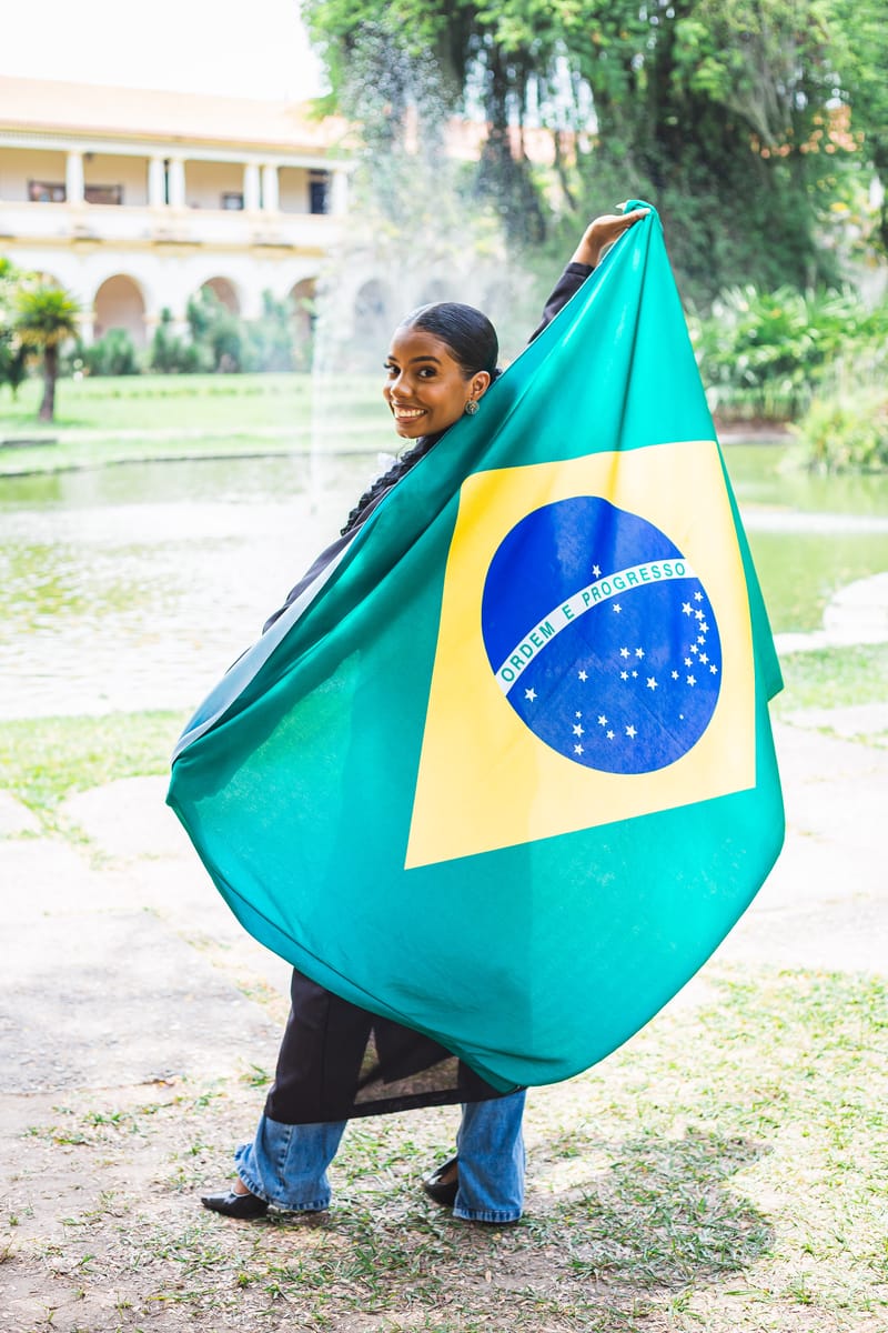 Formanda com a bandeira do Brasil aberta ao vento