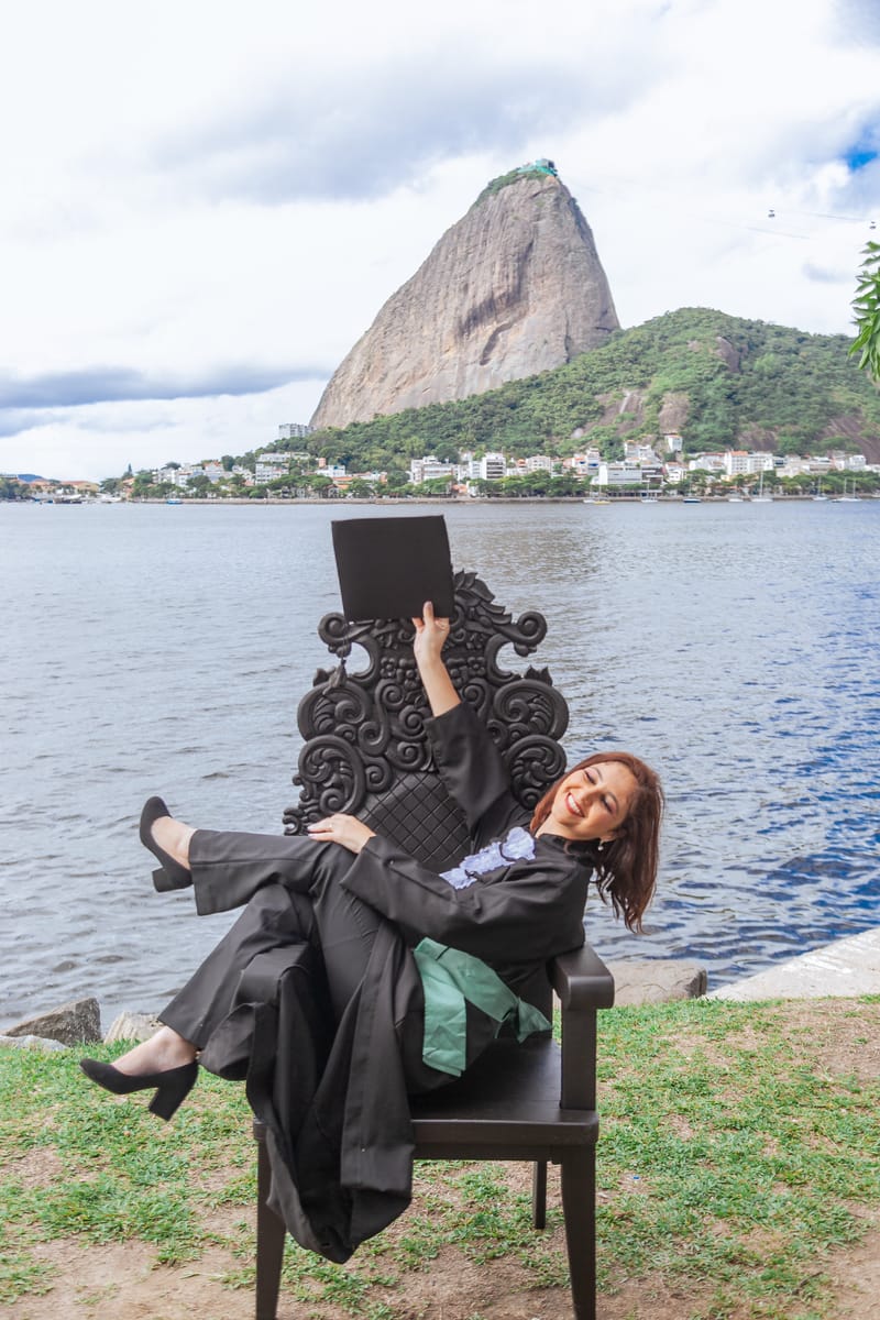 Formanda recostada na cadeira de formatura, de frente para a enseada