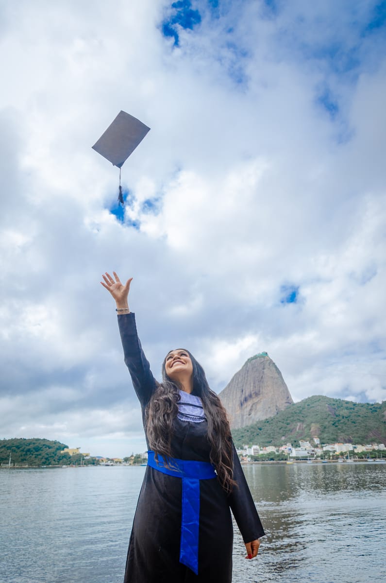 Formanda jogando o capelo com o Pão de Açúcar ao fundo